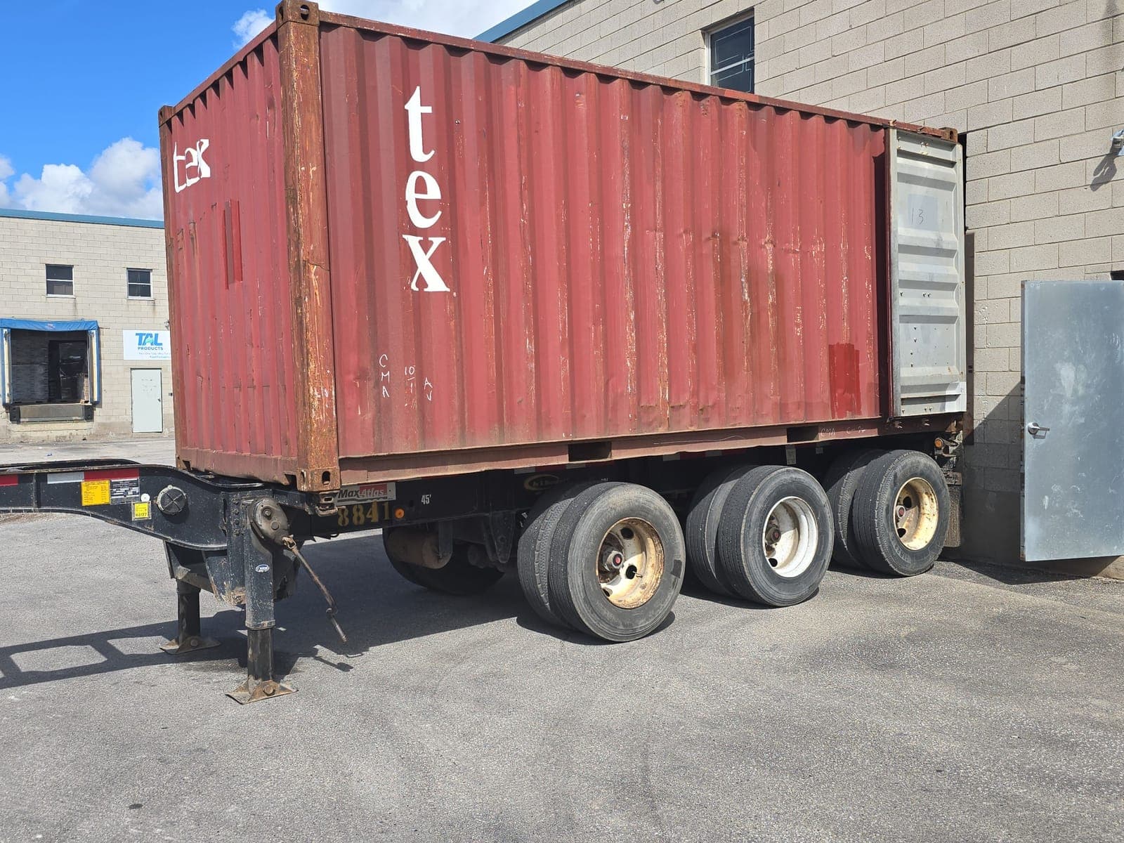 Container on a tri-axle chassis backed up to a customer's loading dock