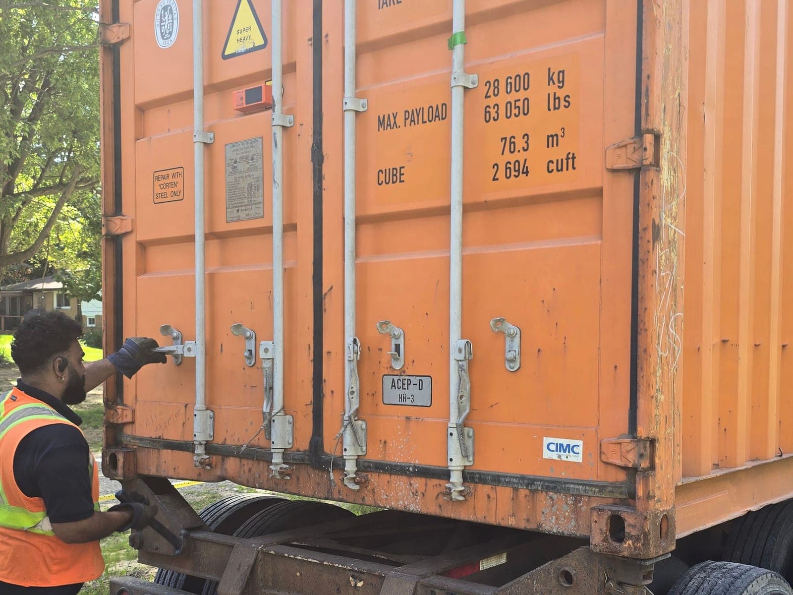 Metropolitan Logistics driver checking the doors of a 40-foot container on the chassis