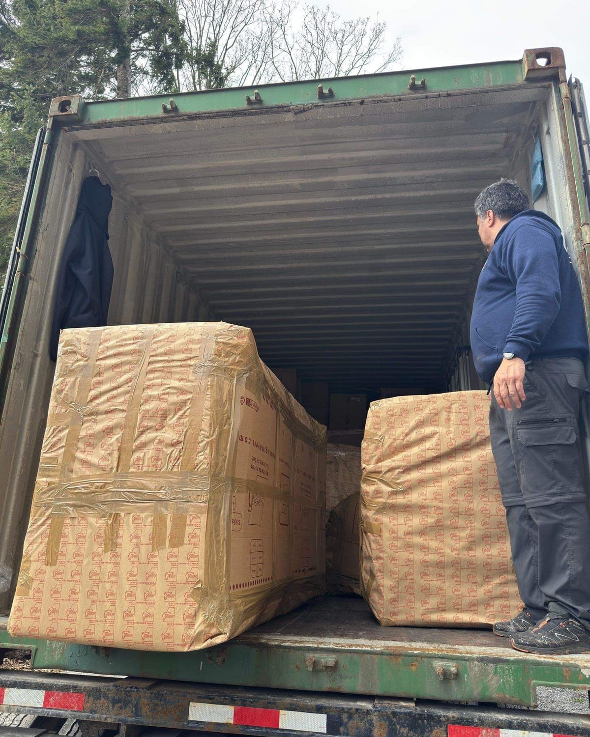 Crew loading wrapped furniture into a container